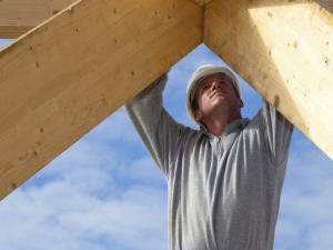 carpenter at work with wooden roof construction